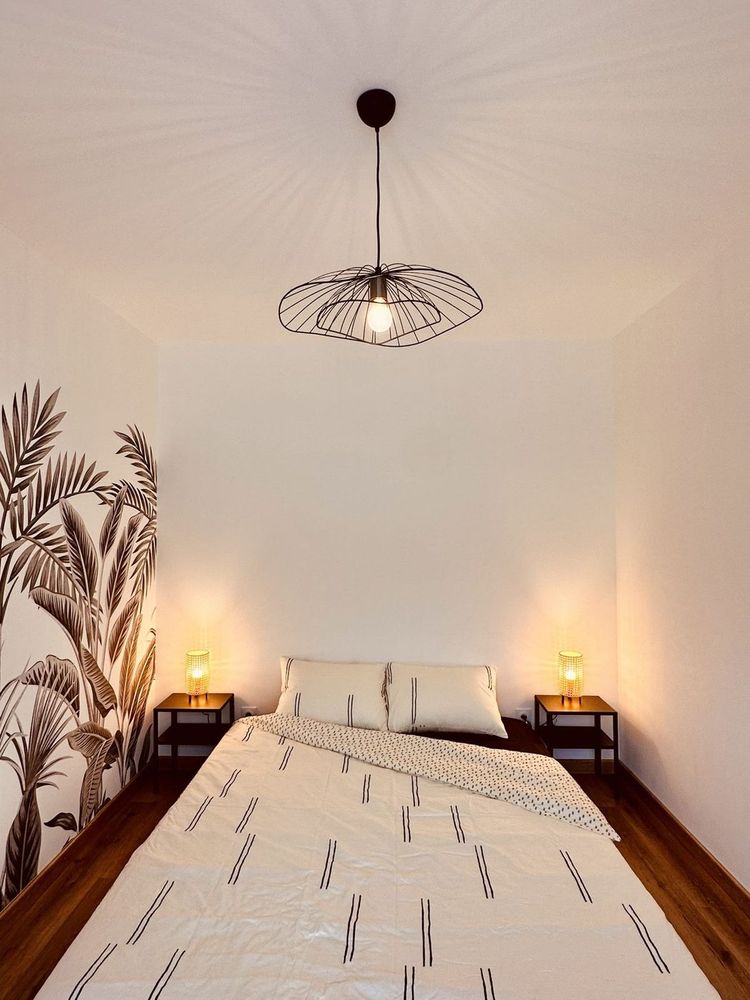 Chambre avec fresque tropicale et lampes de chevet
