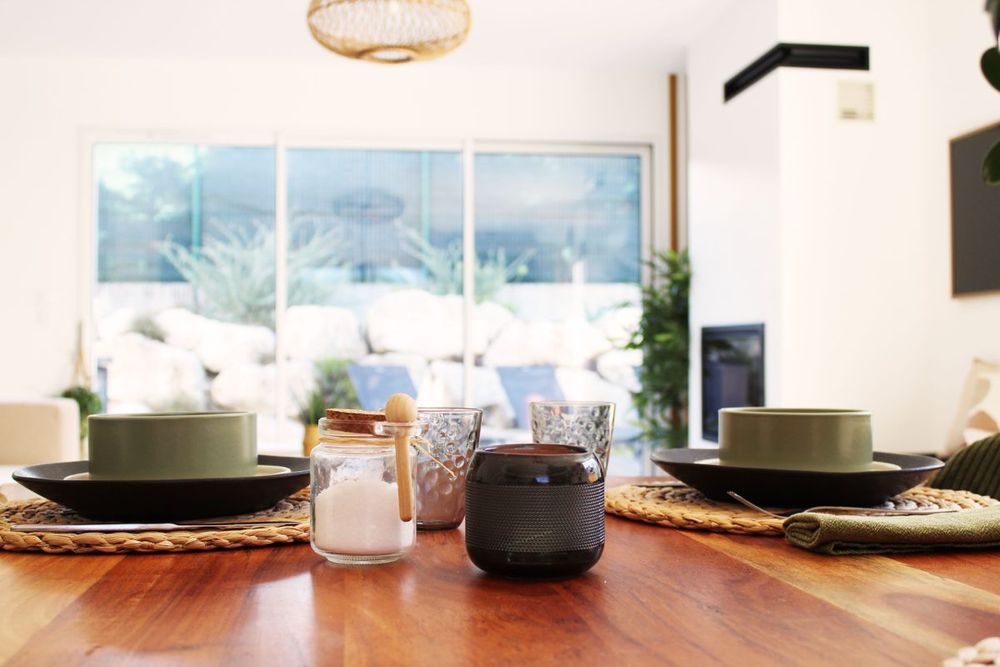Table dressée avec vaisselle et vue sur le séjour